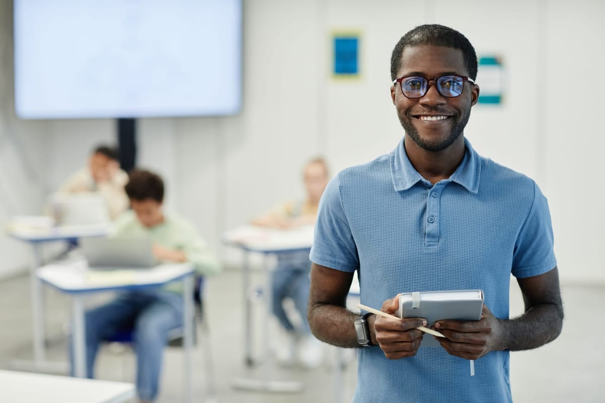 smiling-black-teacher-in-school-classroom-2021-12-16-21-31-41-utc.jpg